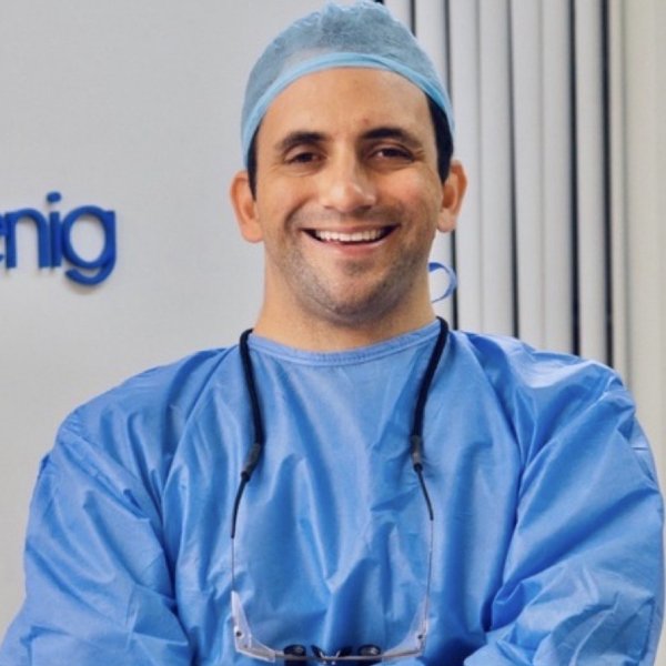 Male surgeon in blue scrubs and cap smiling at the camera Male surgeon in blue scrubs and cap smiling at the camera.
